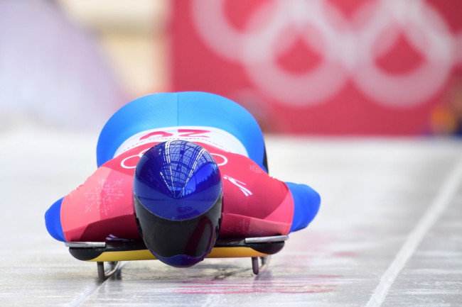 Ukraiński wyścigowiec szkieletowy Władysław Heraskevycz nosi kask ze zdjęciami sportowców poległych na wojnie