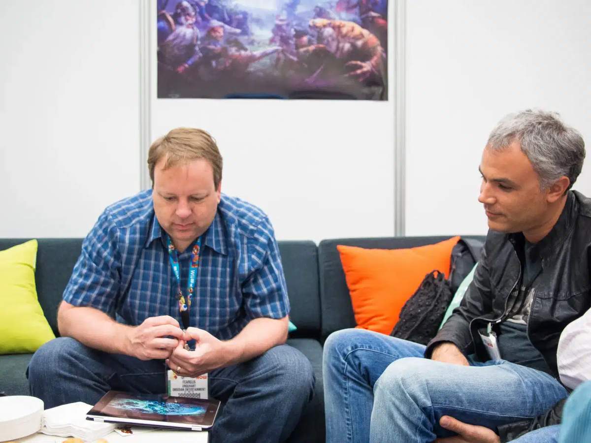 Feargus Urquhart i Sergey Orlovsky siedzący na kanapie podczas targów E3 2013.