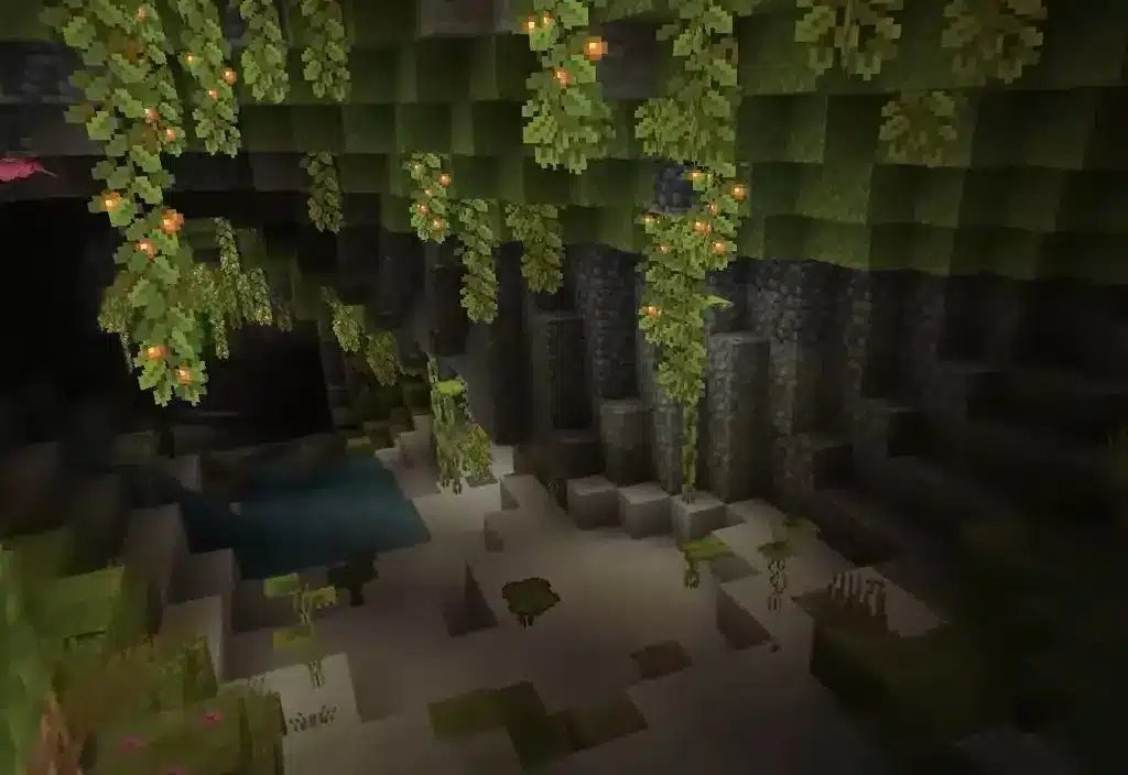 Widok na biom bujnych jaskiń w Minecraft, z wiszącymi świecącymi jagodami i roślinnością.