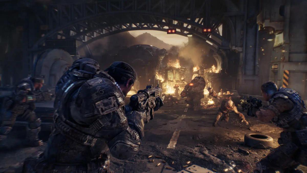 Żołnierze w ciężkich pancerzach walczący z potworami w zrujnowanym środowisku miejskim z Gears of War: E-Day.