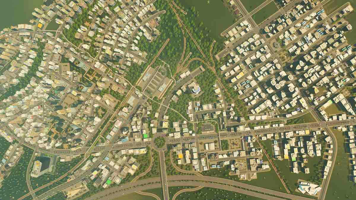 Widok z góry na gęsty układ miasta z drogami oraz budynkami mieszkalnymi i handlowymi w Cities: Skylines